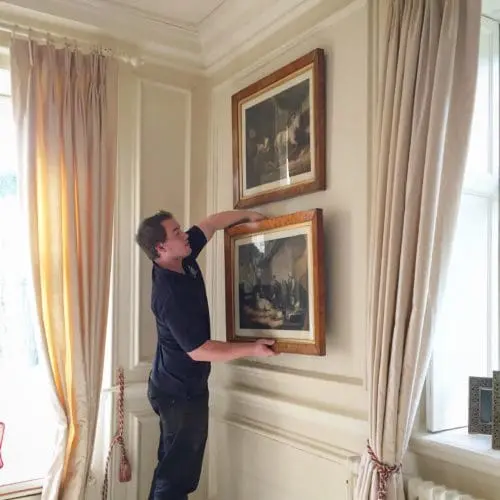 A Williams and White removal expert takes down a piece of artwork.